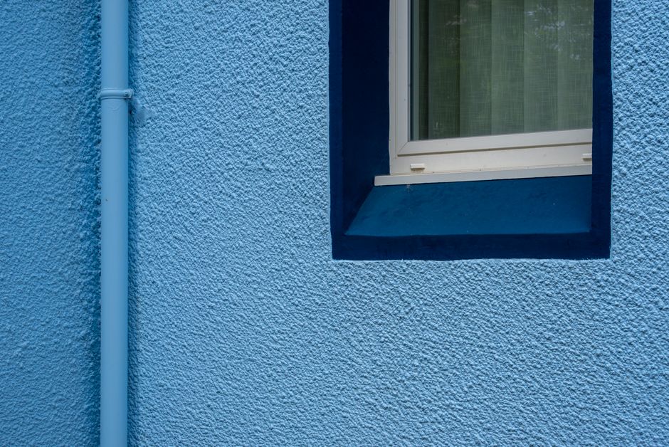 Painted exterior wall of a house with a window and trim
