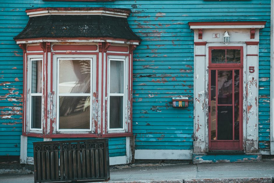 Painted wall surface with a door and window on a house
