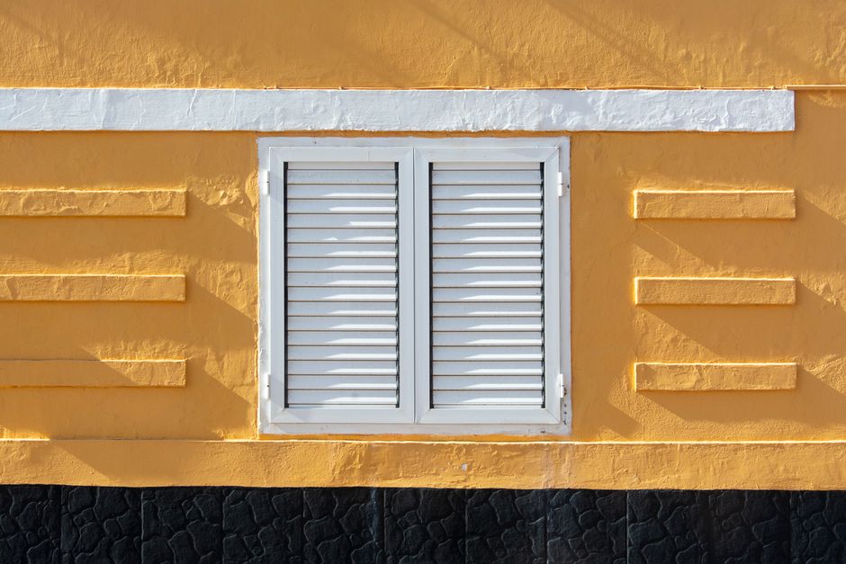 Painted exterior wall of a house with a window and trim